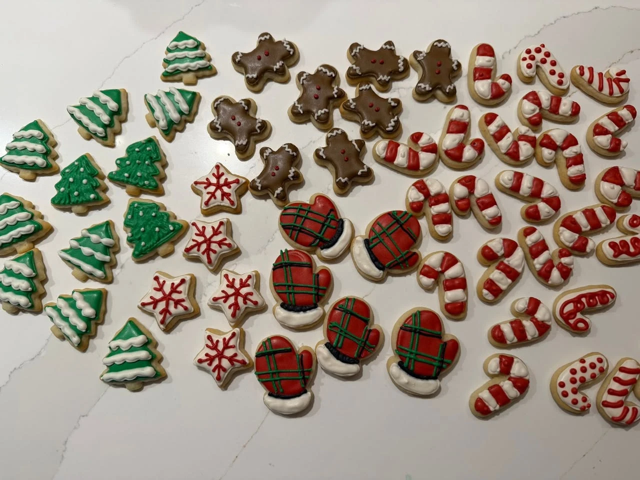 The source Christmas cookie photograph on a plain counter, including trees, gingerbread figures, candy canes, mittens and stars.