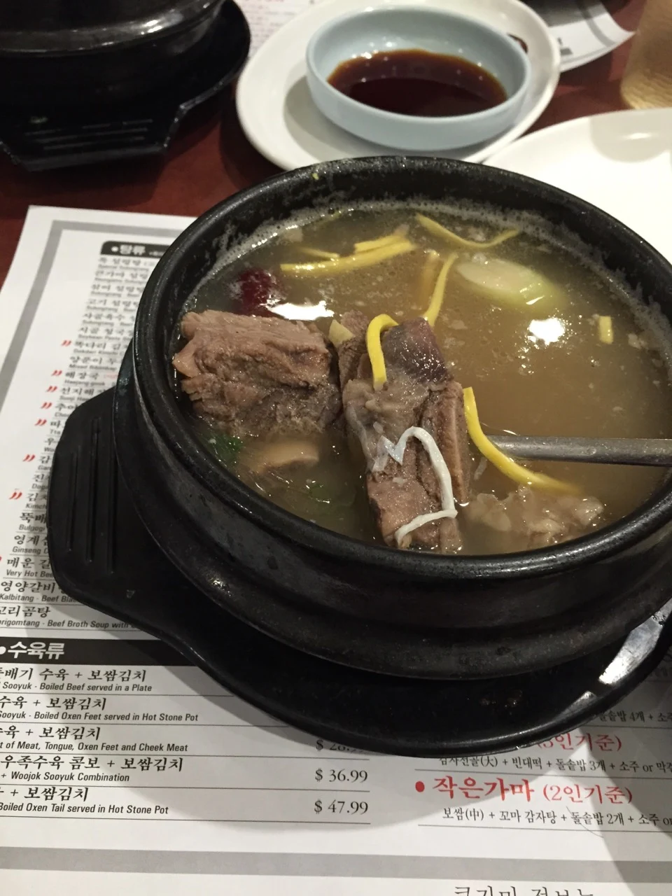 Actual photograph of soup surrounded by a printed placemat, utensils and other table items.